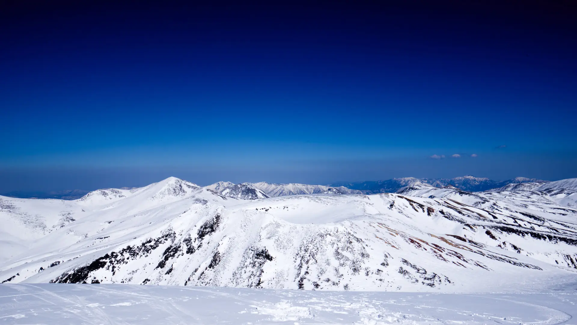Bright winter sunlight over snowy Hokkaido mountains and evergreen forest