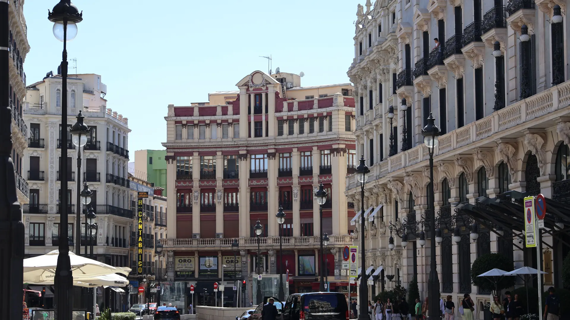 Historic façades and pedestrians on Calle de Sevilla beside Canalejas in Madrid