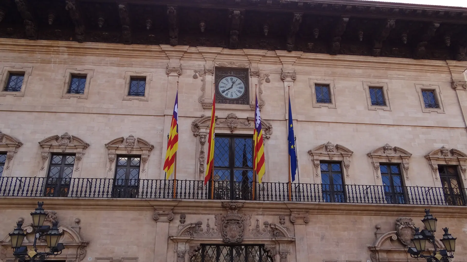 Palma's ornate town hall facade with regional and EU flags on Placa de Cort