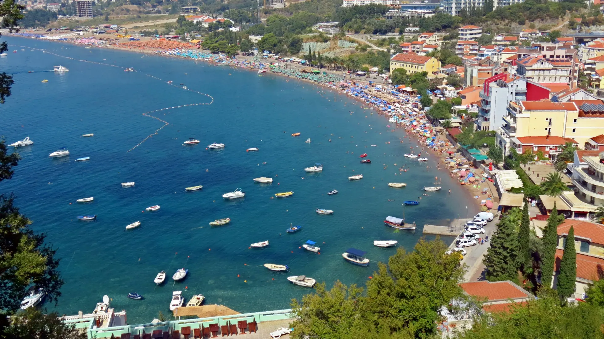Beach umbrellas and turquoise water along the shore at Bečići