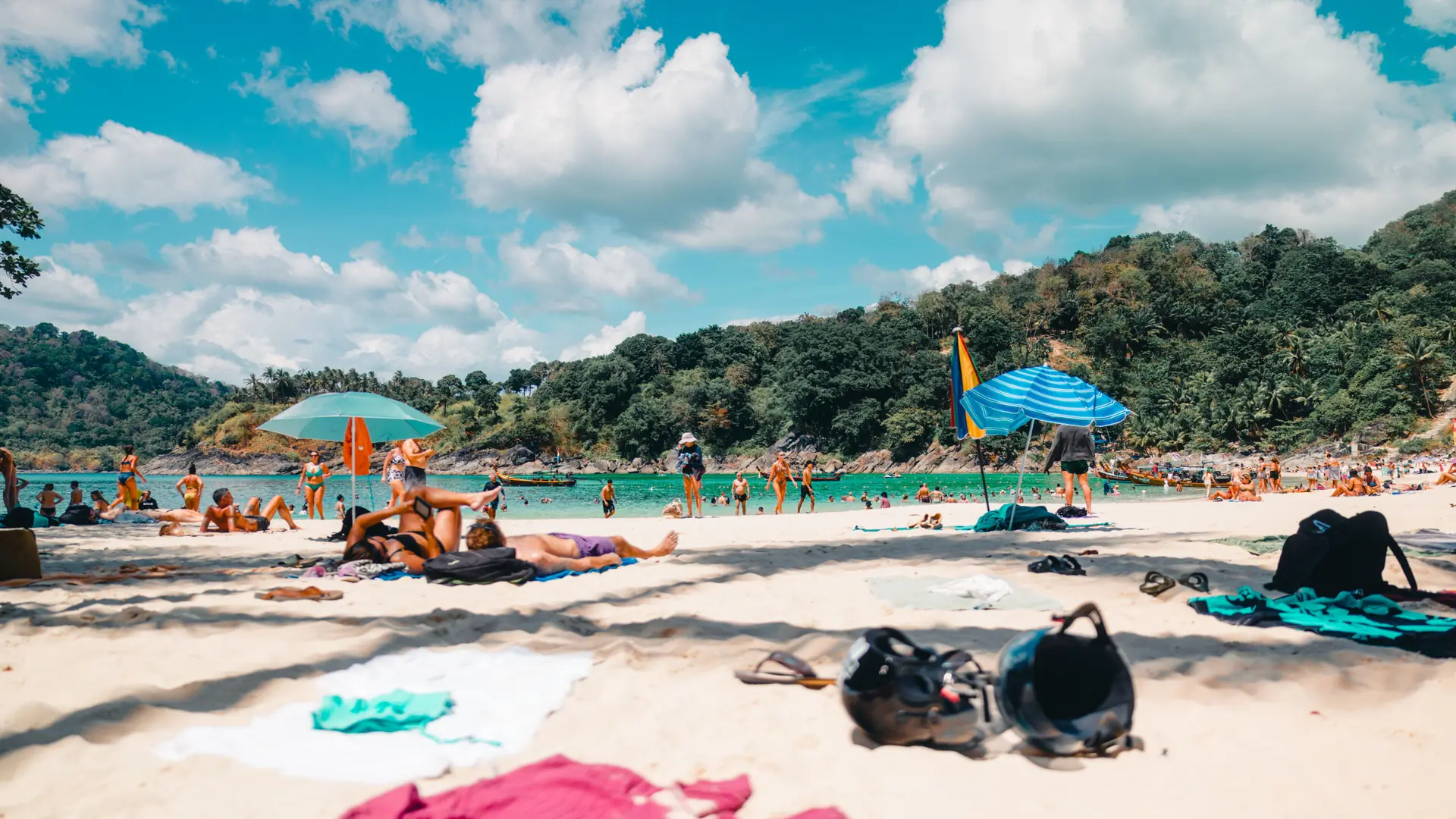 Beachgoers and colourful umbrellas along sunny Kata Beach