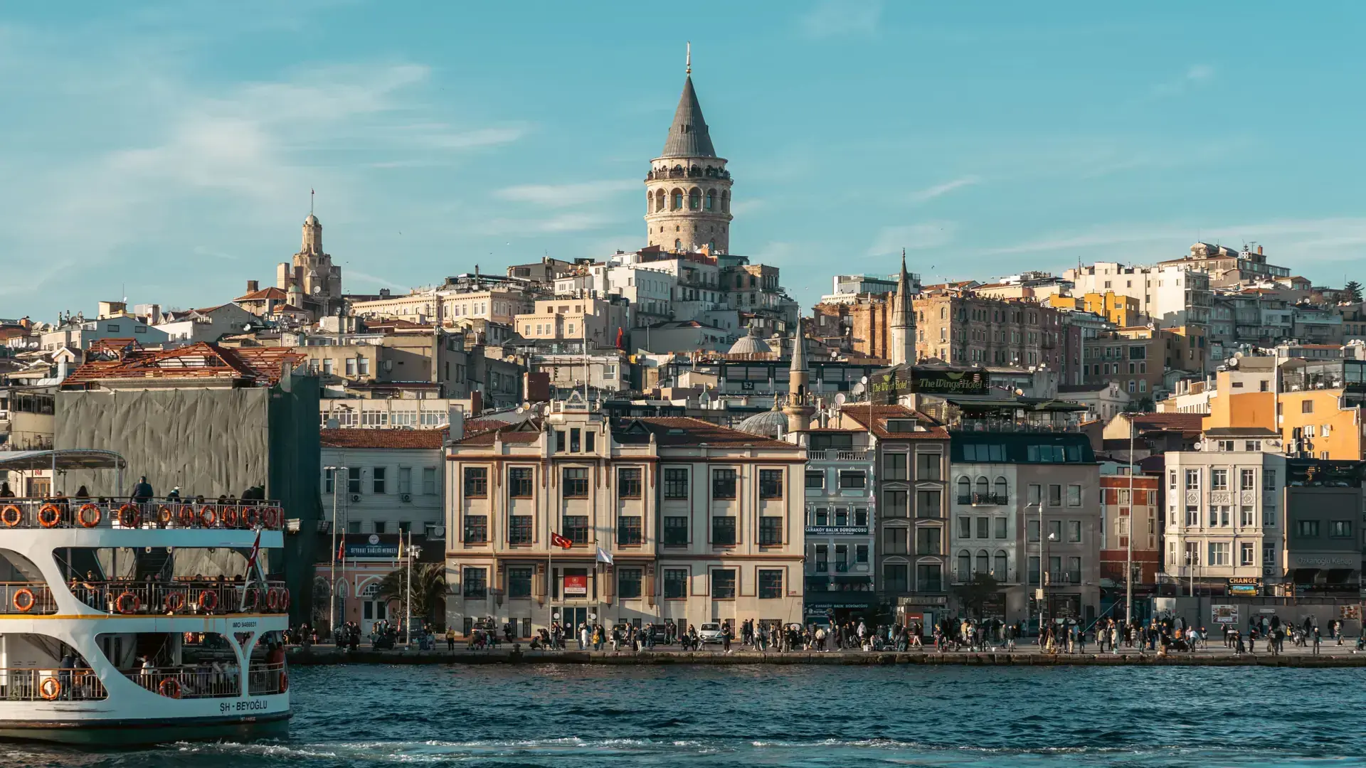 Galata Tower above sunlit streets descending toward Karakoy and the Bosphorus