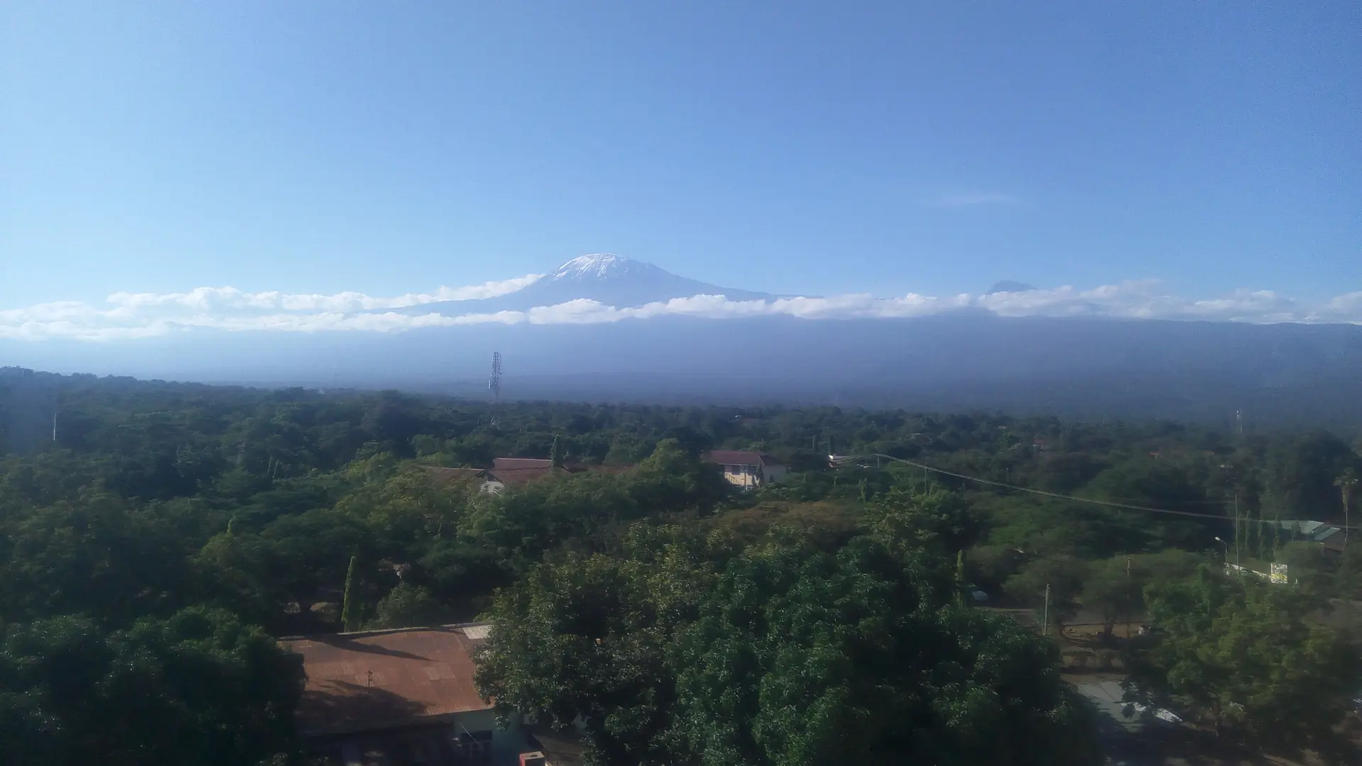 Mount Kilimanjaro above green Moshi town on a clear day