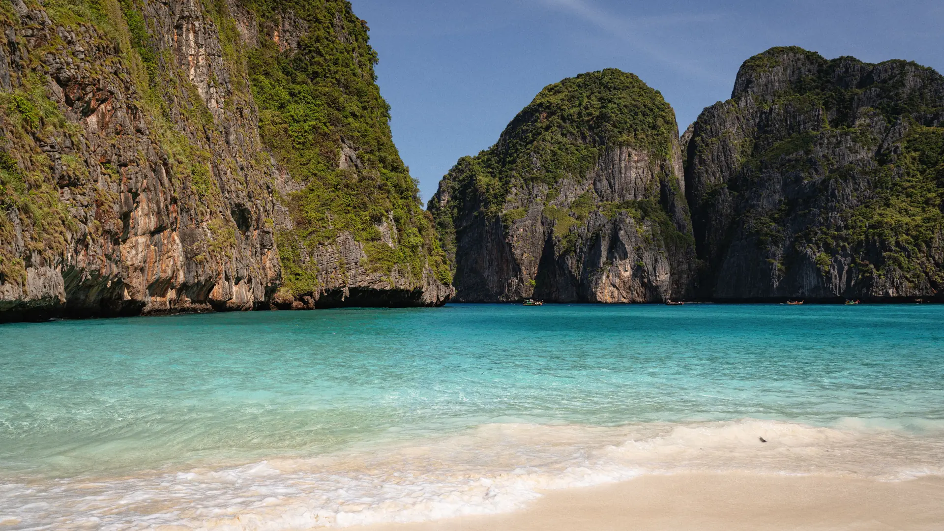 Maya Bay's turquoise water enclosed by sheer green limestone cliffs