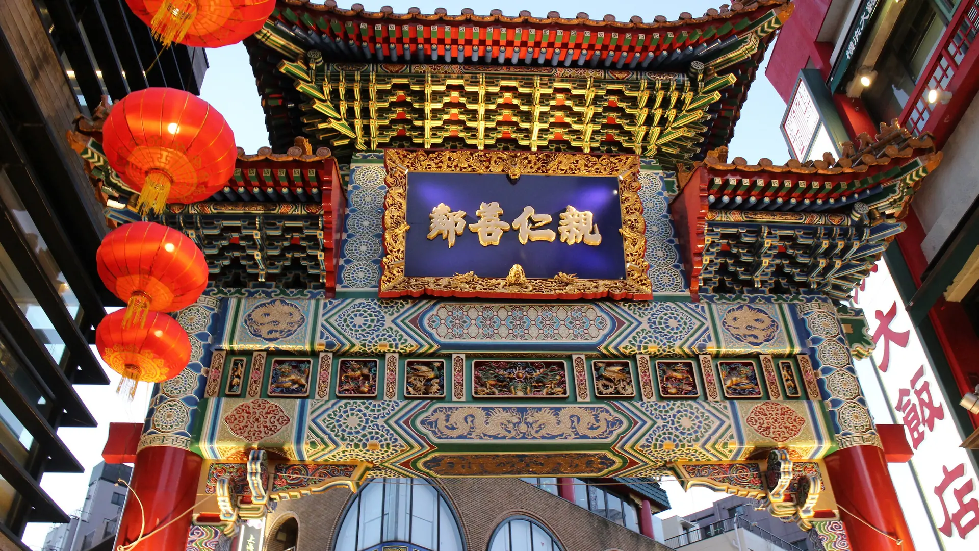 Painted beams, red lanterns and the rear plaque of Zenrinmon in Yokohama Chinatown.