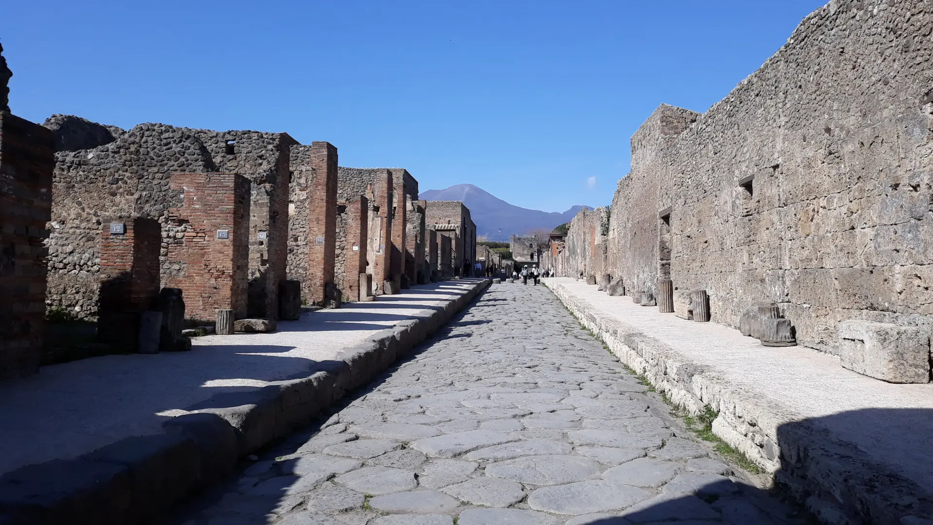 Ancient stone street in Pompeii with Mount Vesuvius in the distance
