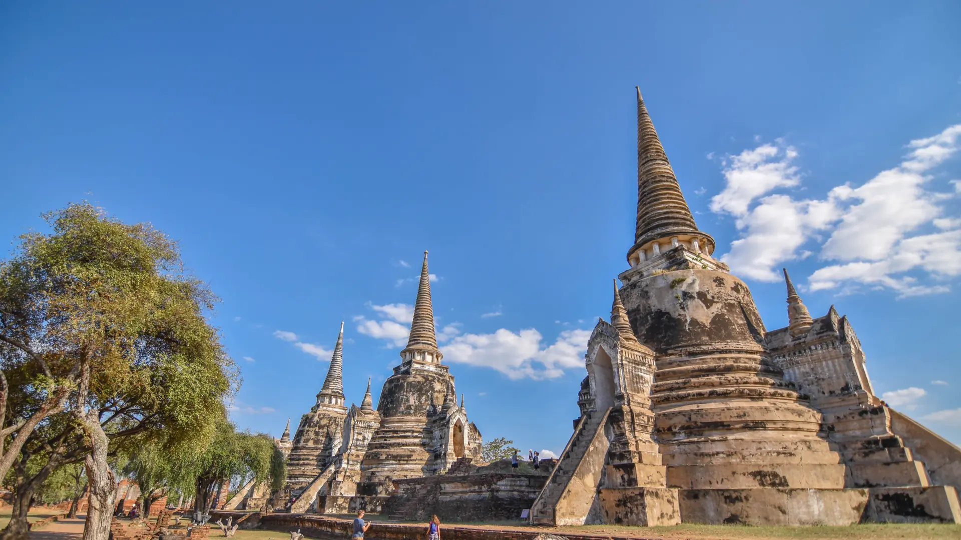 Ancient brick pagodas in Ayutthaya Historical Park beneath a clear blue sky