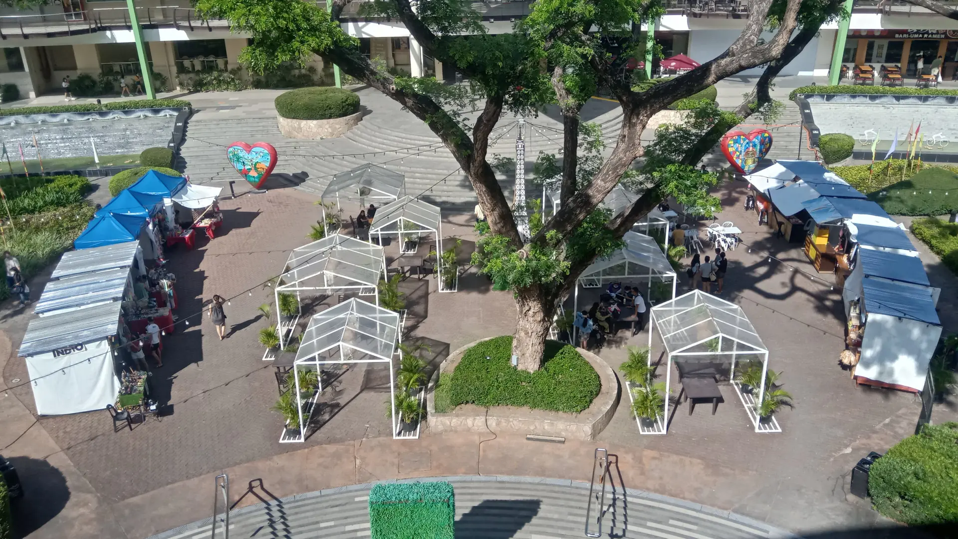Sunlit outdoor terraces, trees and food stalls at Ayala Center Cebu