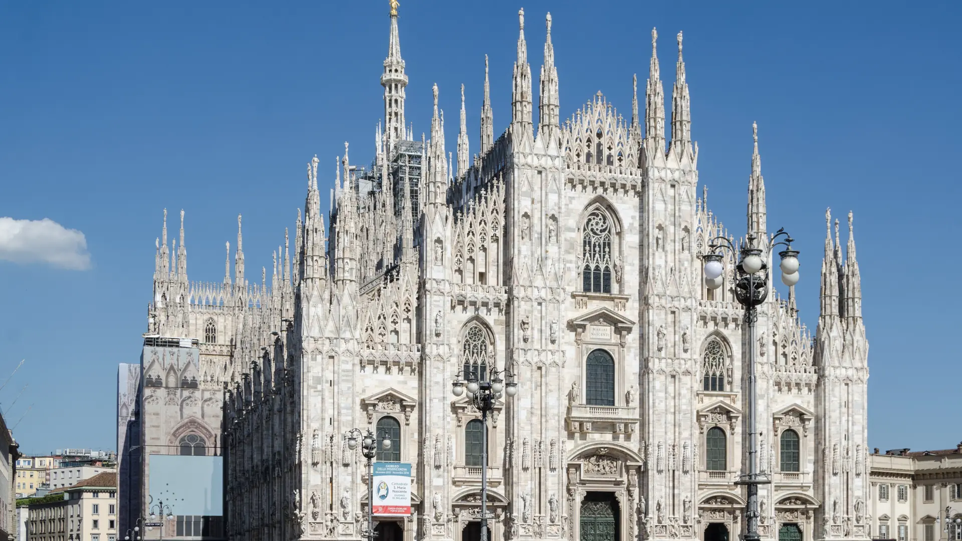Milan Cathedral’s marble façade facing an open Piazza del Duomo.