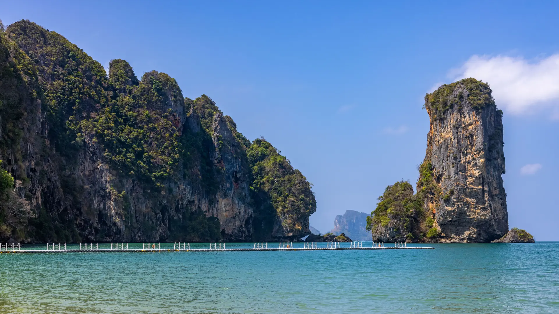 Limestone headlands rising from blue water off Ao Nang in Krabi