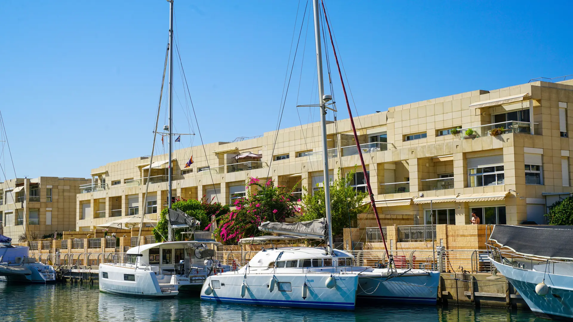 sailboats moored beside Albufeira Marina's cream apartment buildings and bougainvillea