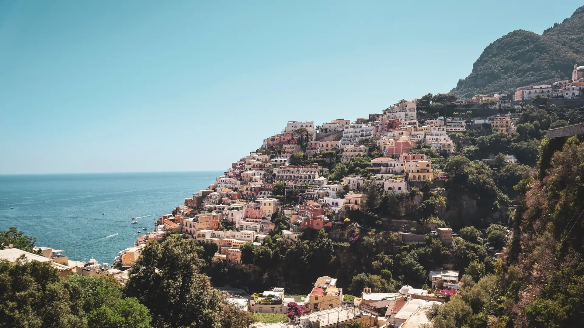 Sunlit Amalfi Coast village above a deep blue Tyrrhenian Sea