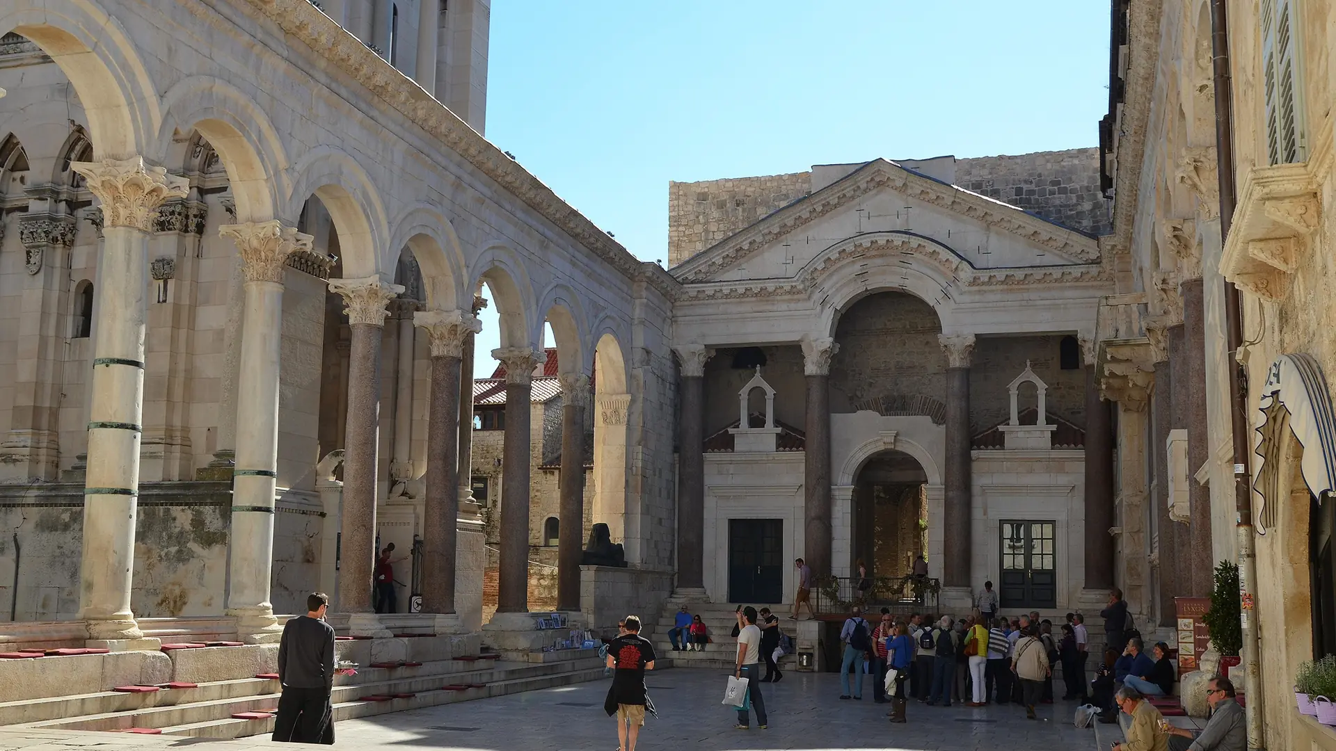 Visitors walking through the sunlit stone passages of Diocletian's Palace in Split