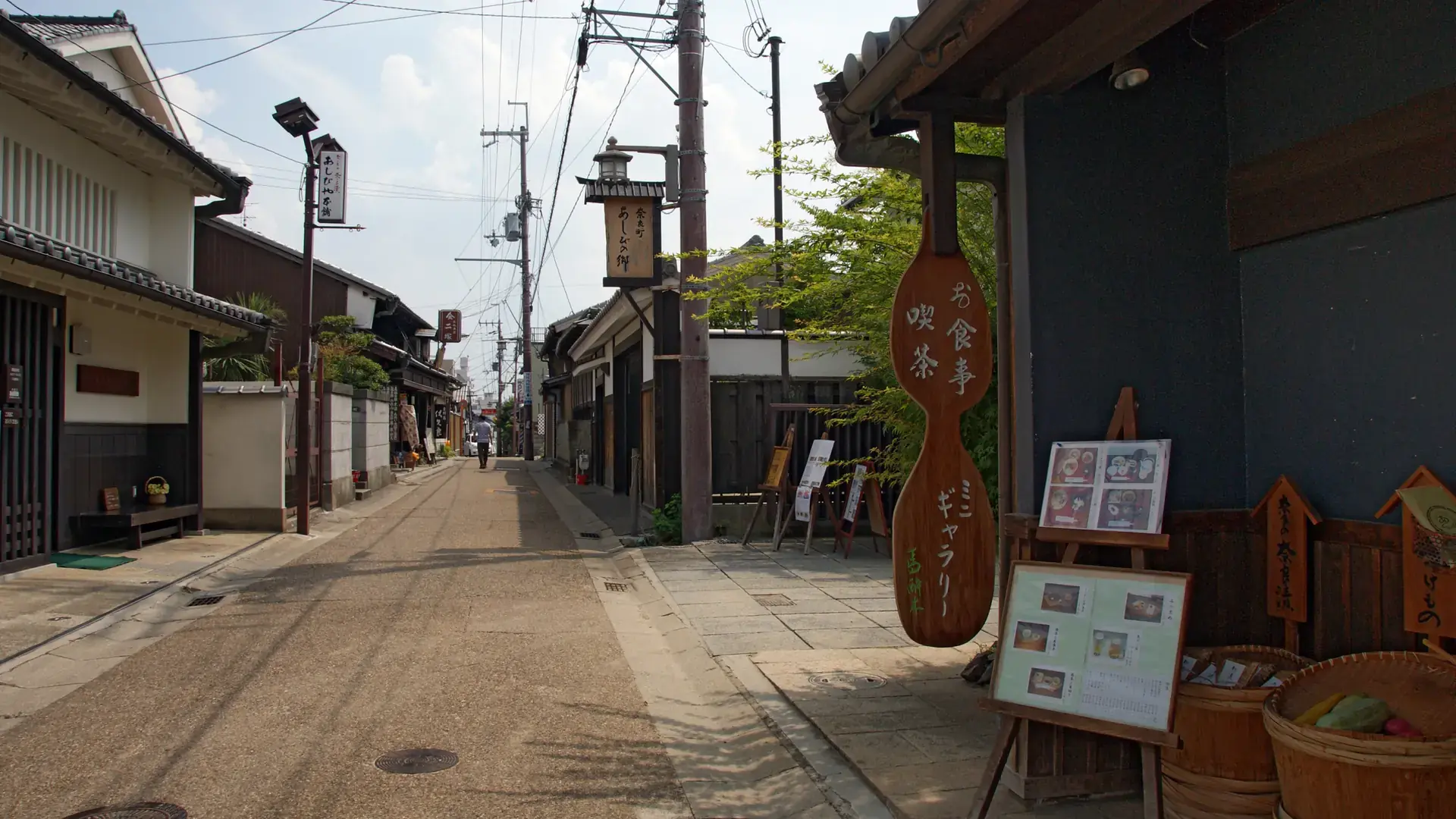 traditional wooden machiya and red charms along a bright Naramachi lane