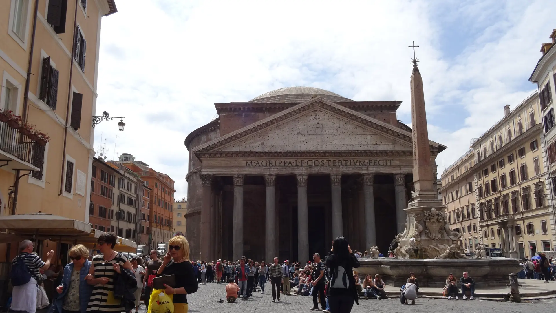 the Pantheon's ancient columned portico and Latin inscription, sunlit with visitors in Rome's historic centre