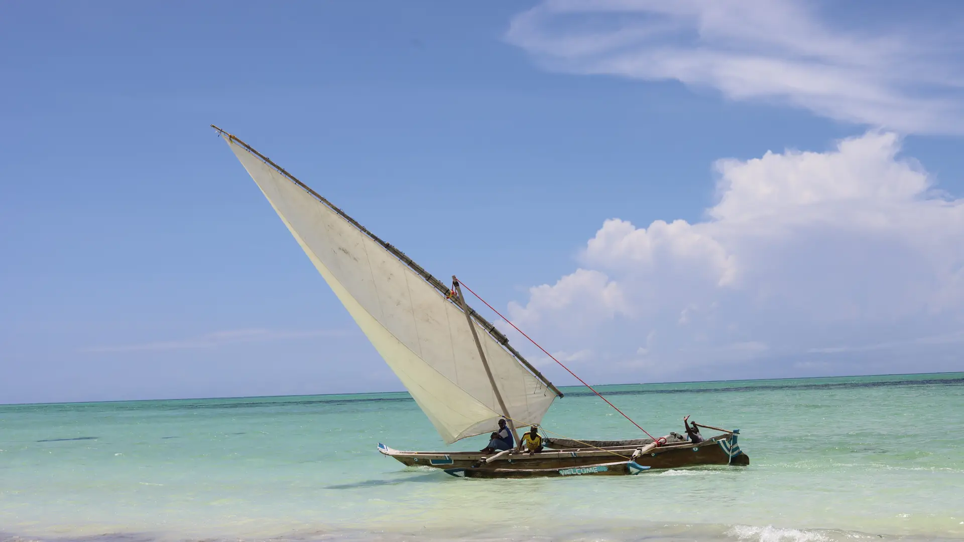 Traditional dhow sailing in bright water off Zanzibar Island