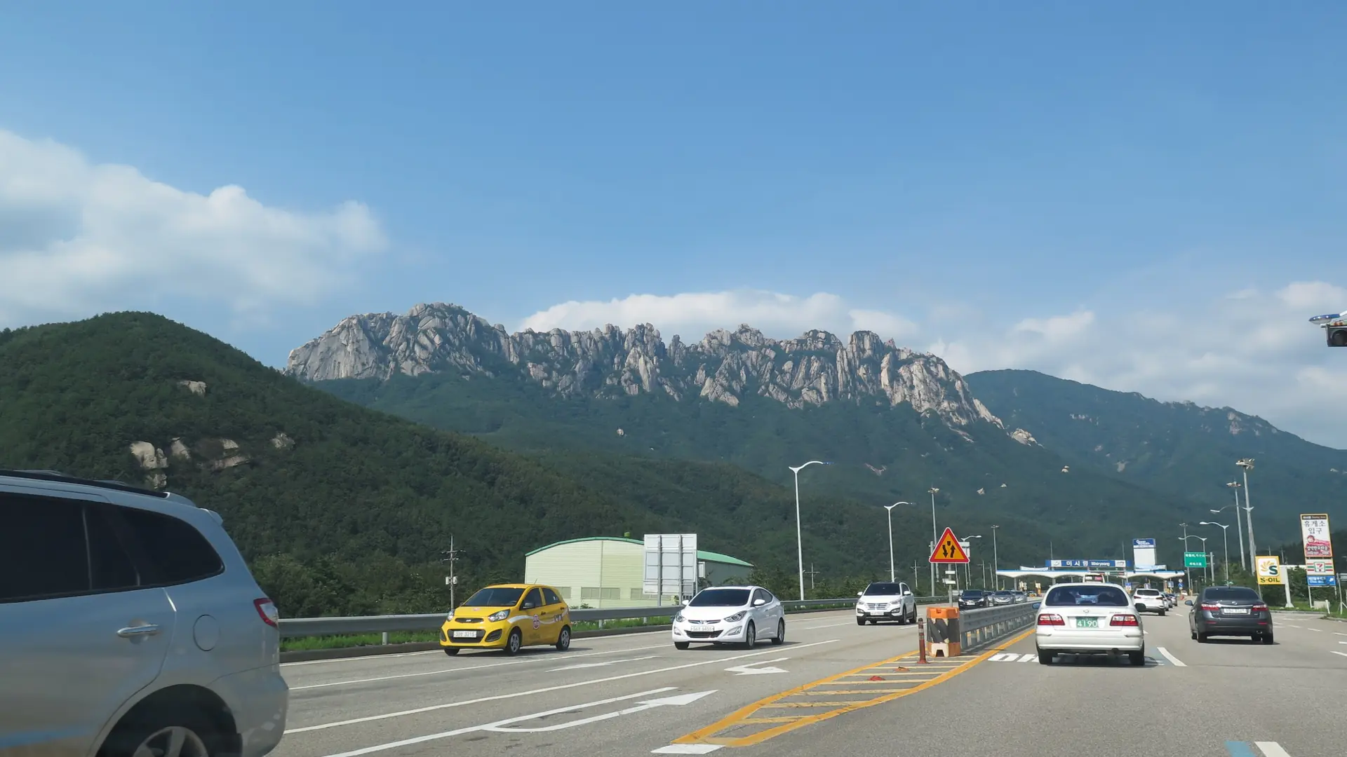 Seoraksan's jagged granite Ulsanbawi Rock ridge rising above forested foothills under a clear blue sky near Sokcho