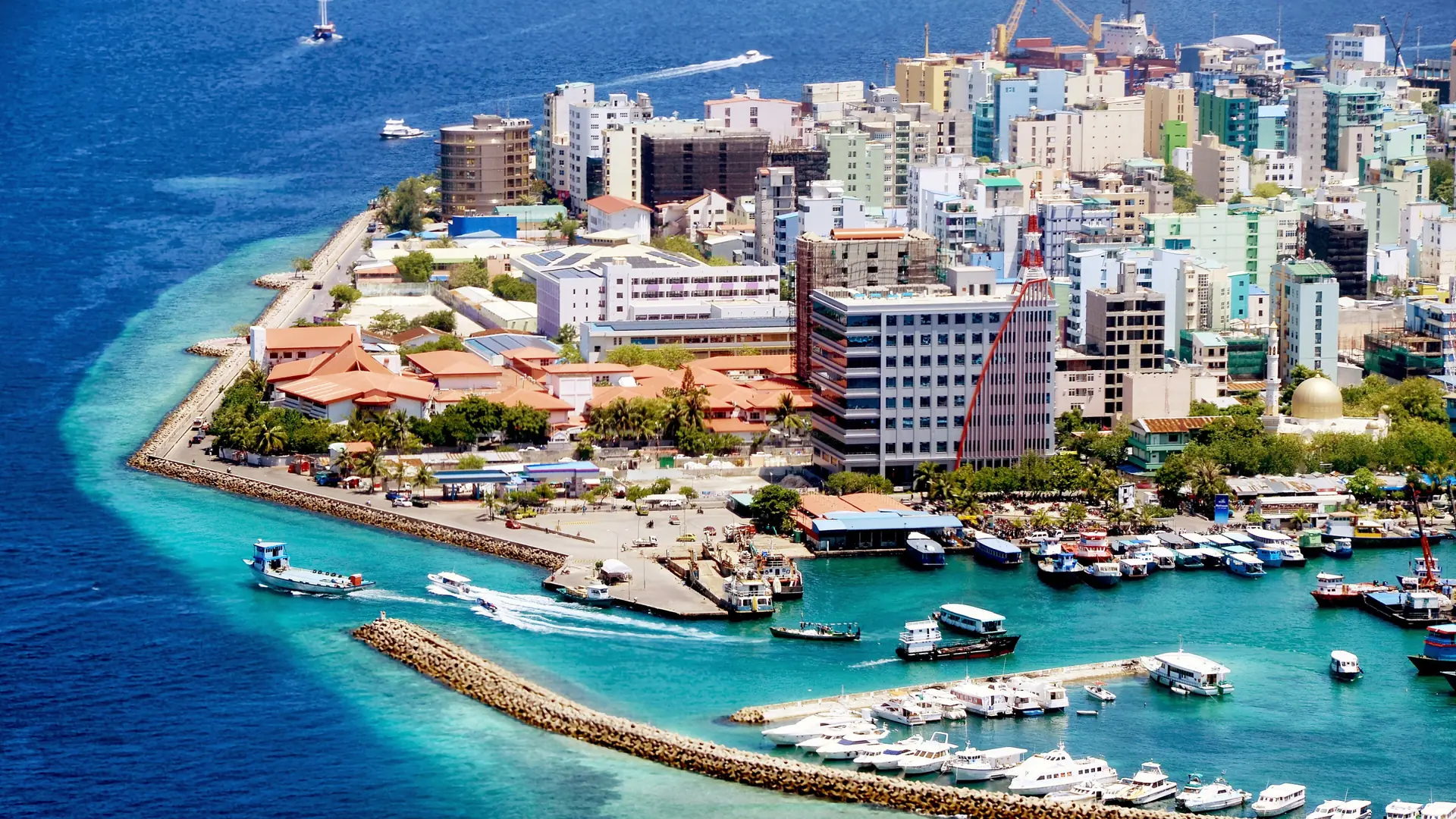 Sunny aerial view of Malé island, its dense city blocks and turquoise surrounding water
