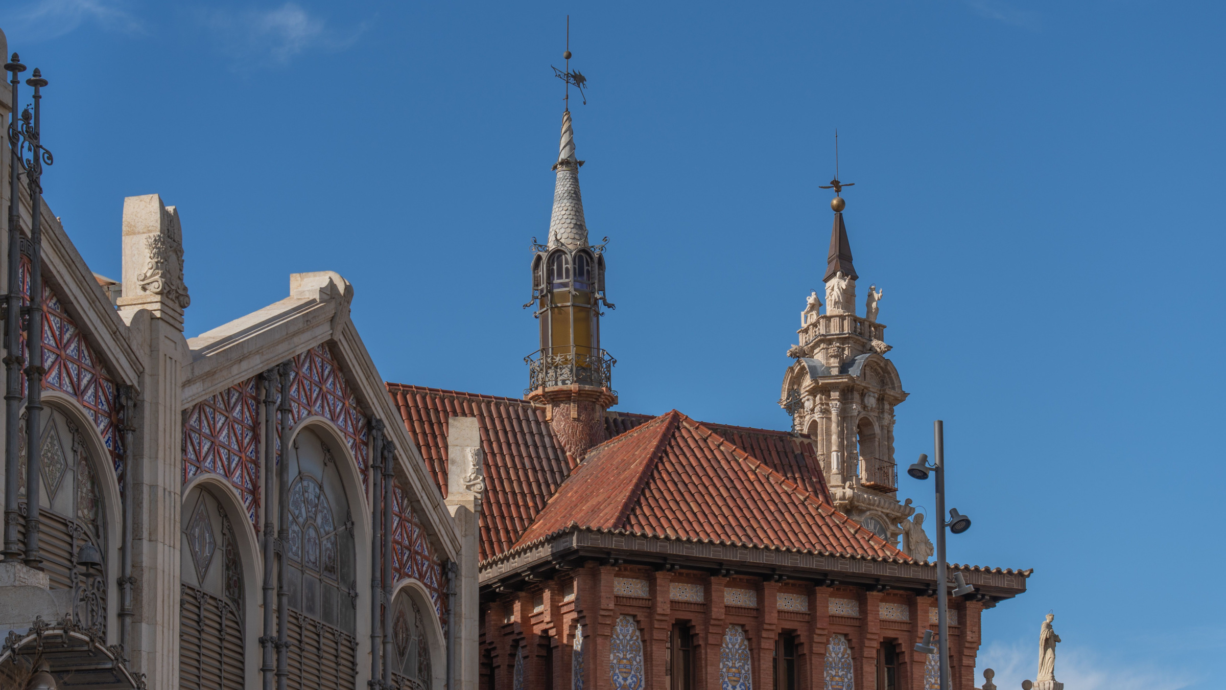 Central Market roofs and decorative towers under a blue sky in Valencia