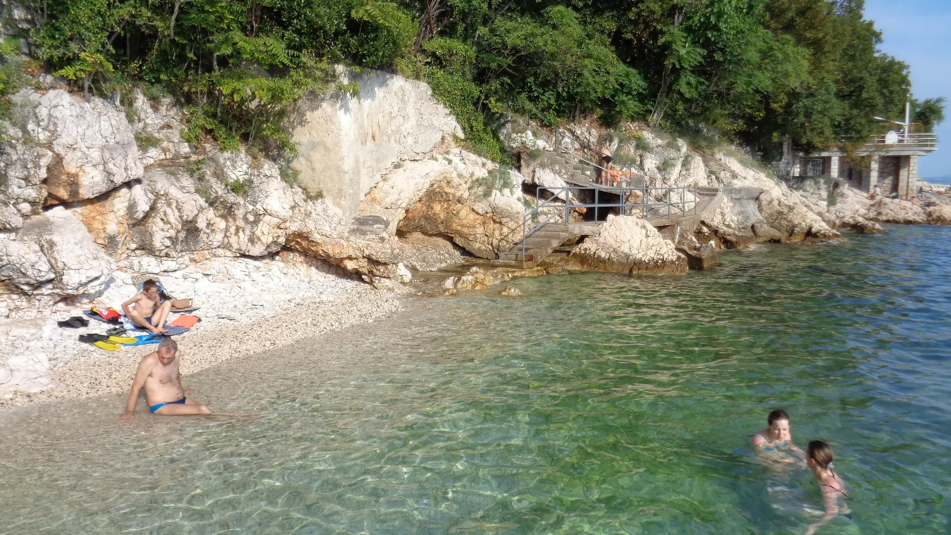Swimmers beside pebbles and rock at Glavanovo beach in Pećine