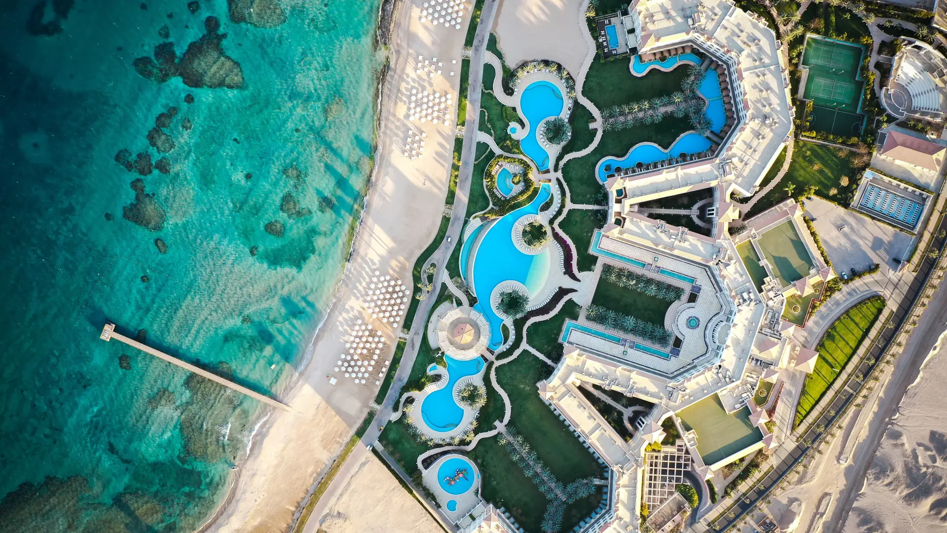 Aerial view of a Hurghada coastal resort with pools beside turquoise Red Sea water