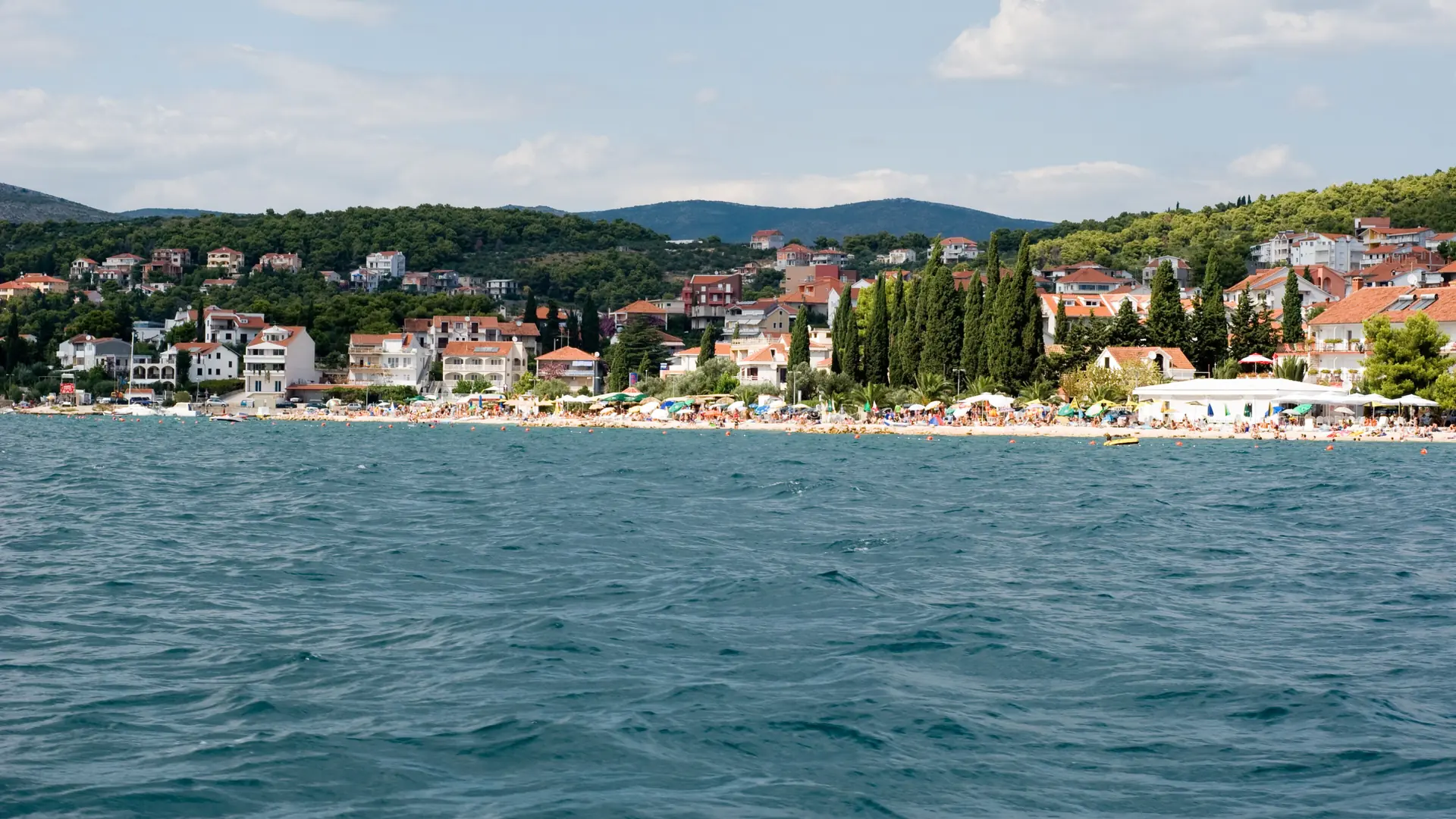 Swimmers and waterfront houses along Copacabana Beach in Okrug Gornji on Čiovo