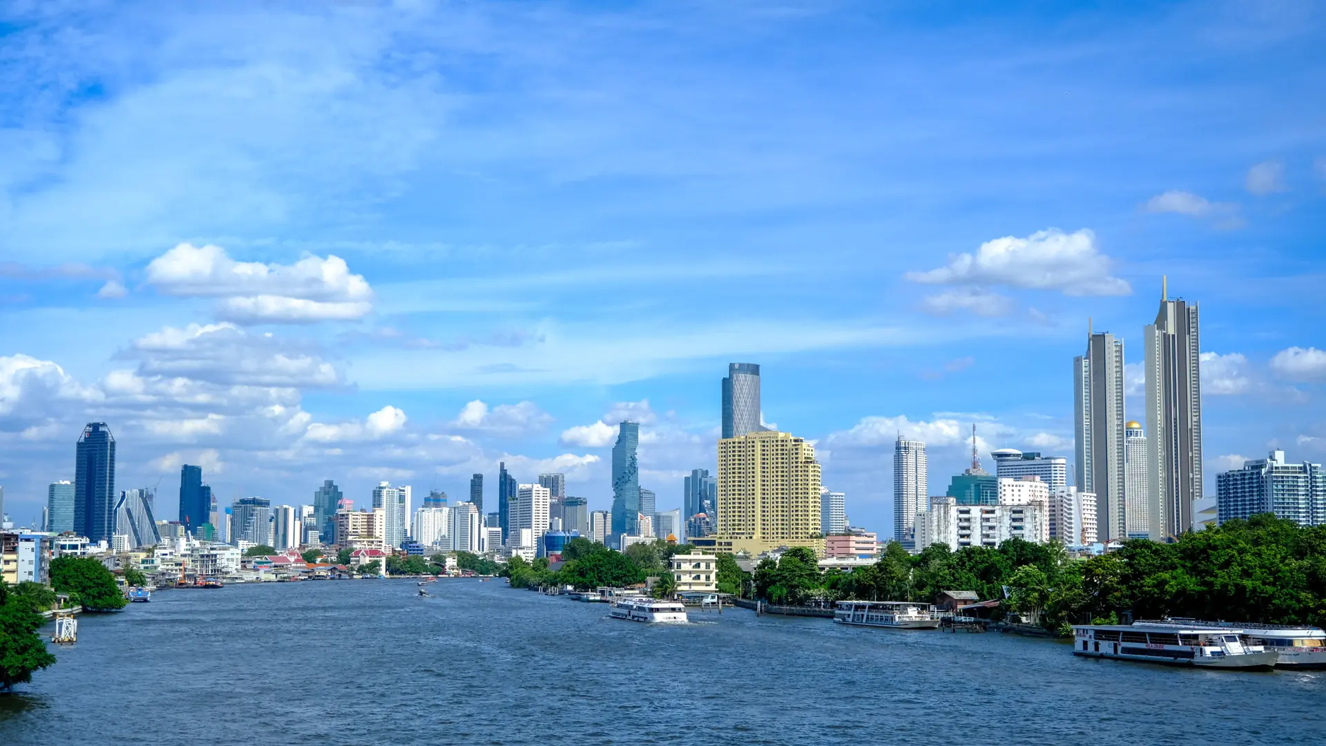 Bangkok's riverside skyline glowing above the Chao Phraya before the island journey south