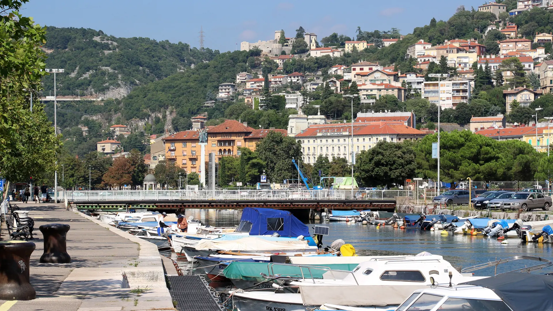 Rijeka’s dense waterfront city rising from the Kvarner port toward green hills in bright daylight