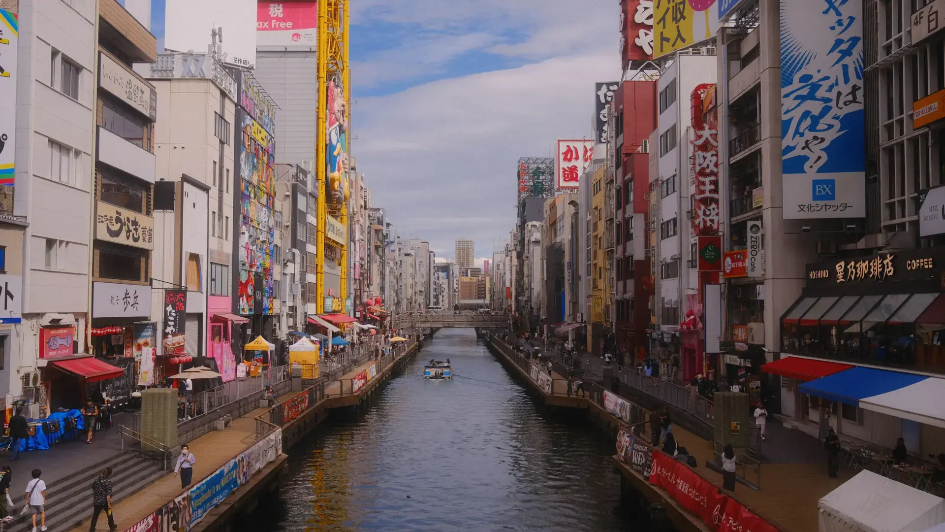 bright Dotonbori canal with colourful signs and Osaka waterfront buildings