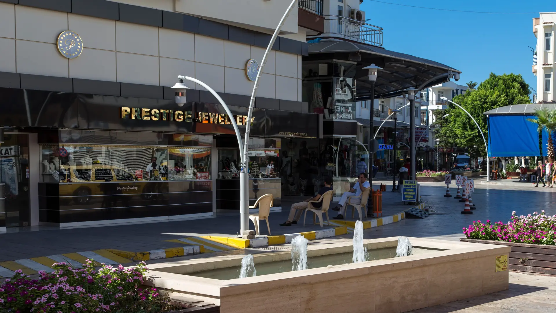 Fountain and shops in Belek town in sunshine, a wider city scene rather than Boğazkent beach
