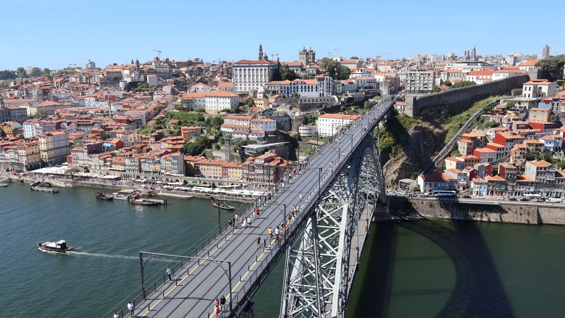 Sunlit view over Porto's tiled rooftops, the Douro and the Dom Luís I Bridge