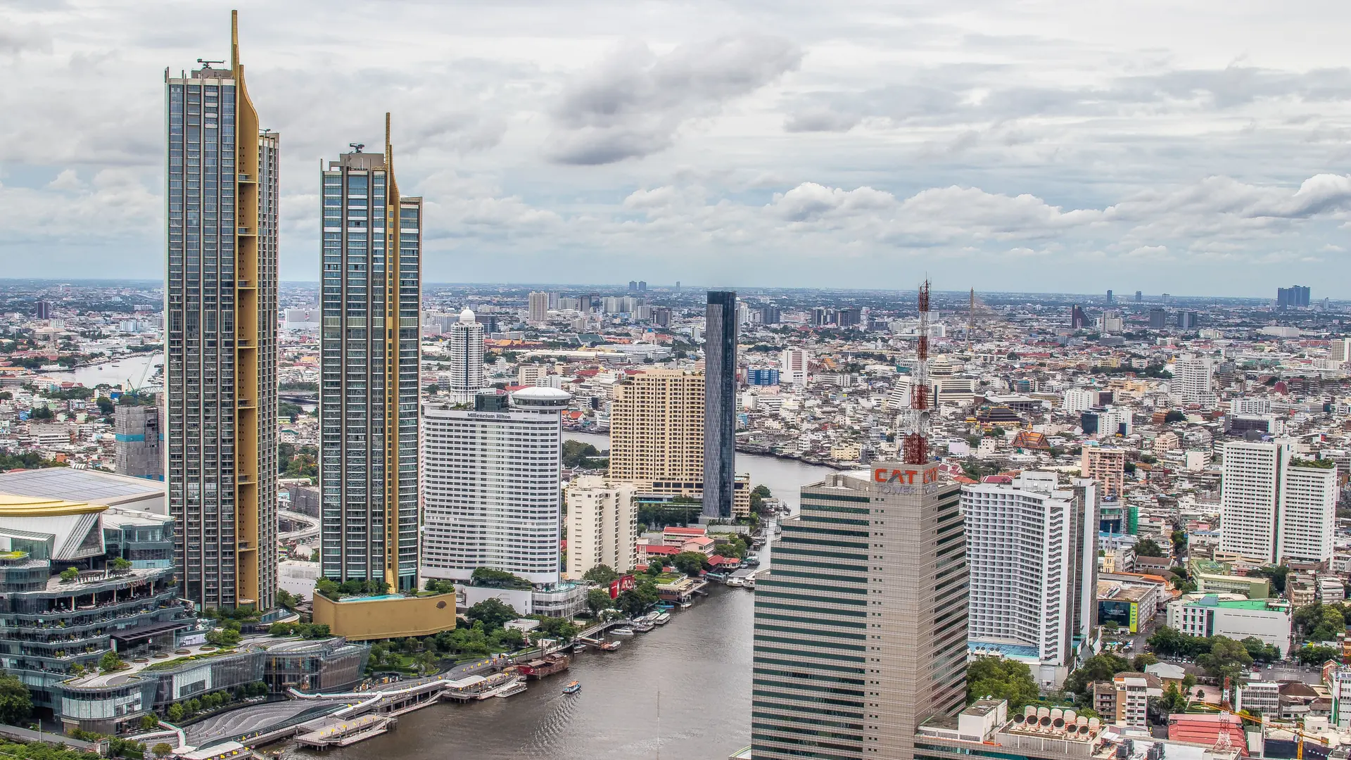 Bangkok towers rising beside the broad Chao Phraya River in clear daylight