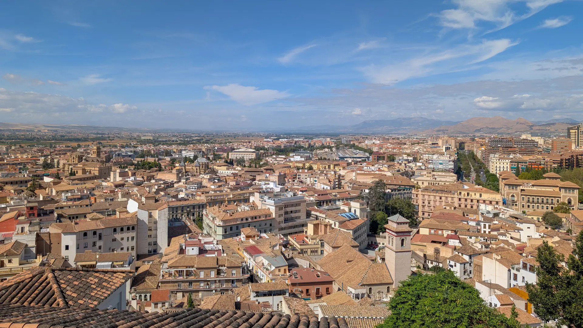 Granada rooftops and church towers beneath a blue sky