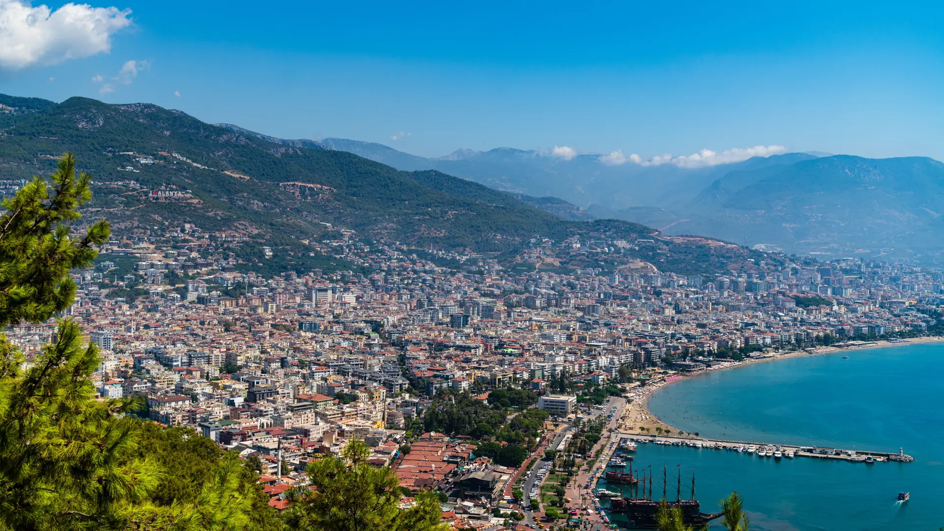 Alanya harbour, eastern city waterfront and mountain slopes viewed from the castle in daylight