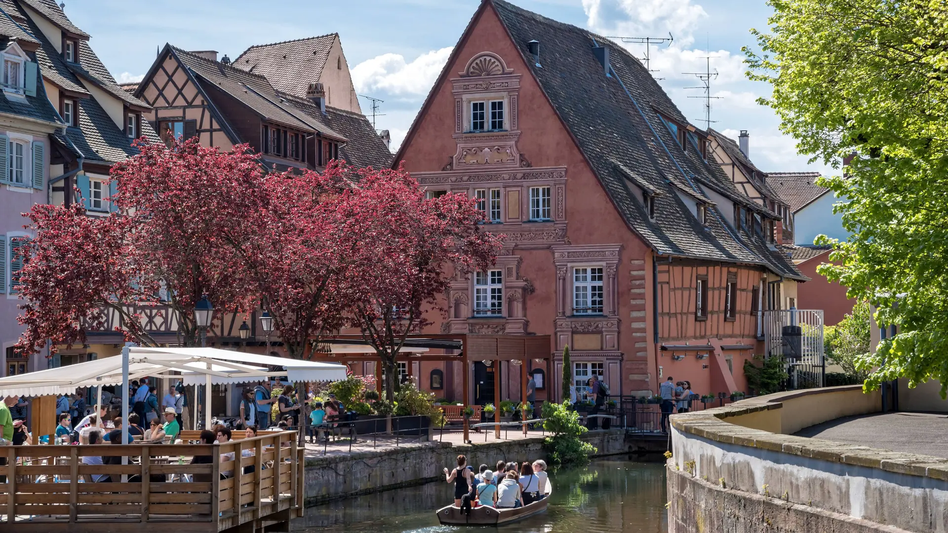 A boat and half-timbered waterfront houses in Little Venice, Colmar