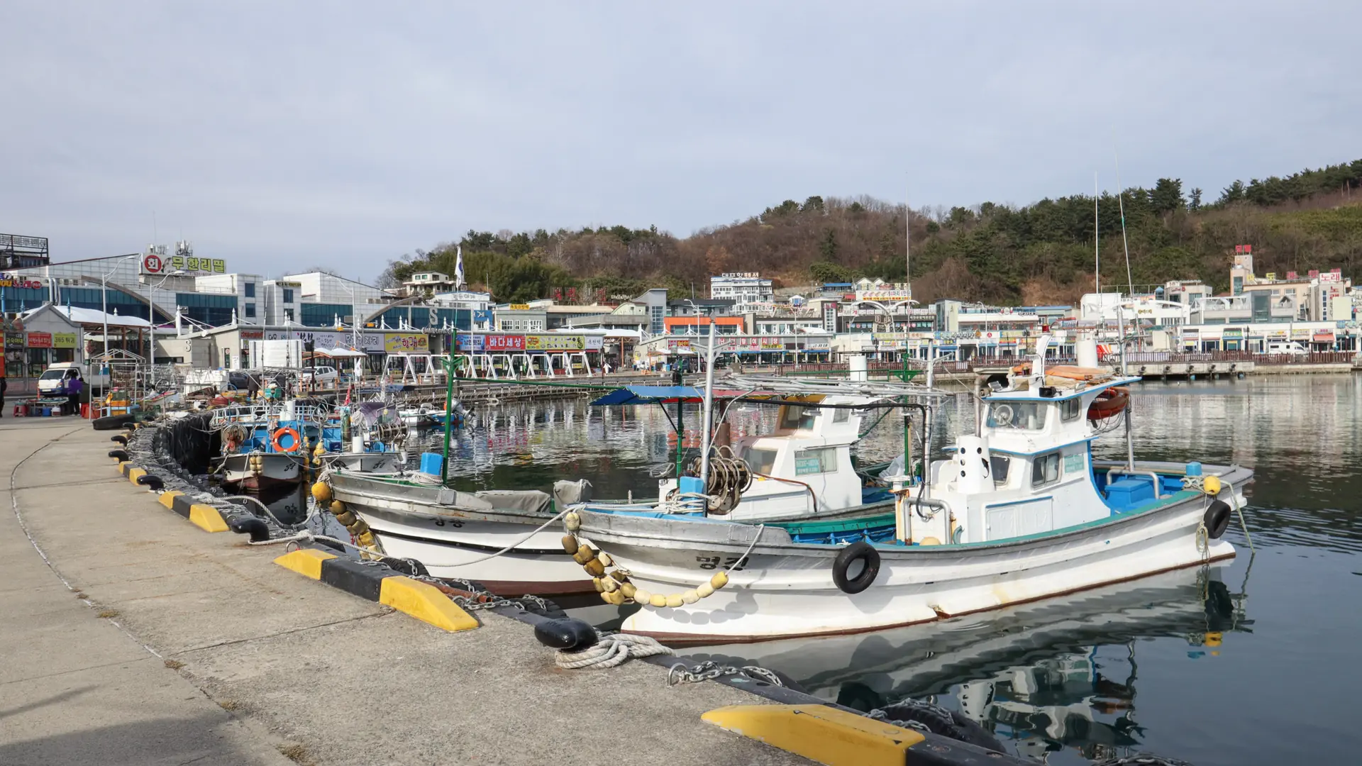 Fishing boats moored beside waterfront restaurants in Daepo Port, Sokcho