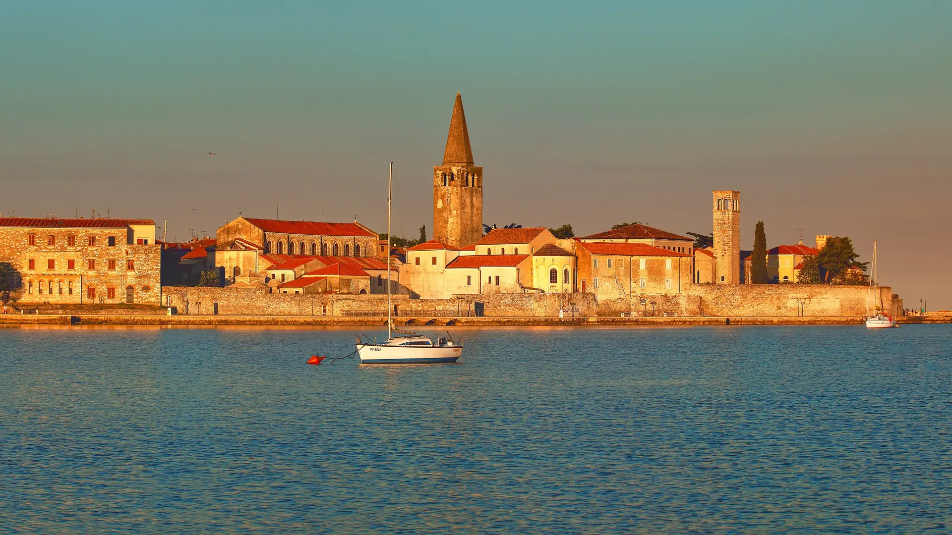 Morning sunlight on Poreč Old Town and the Euphrasian Basilica bell tower across the water