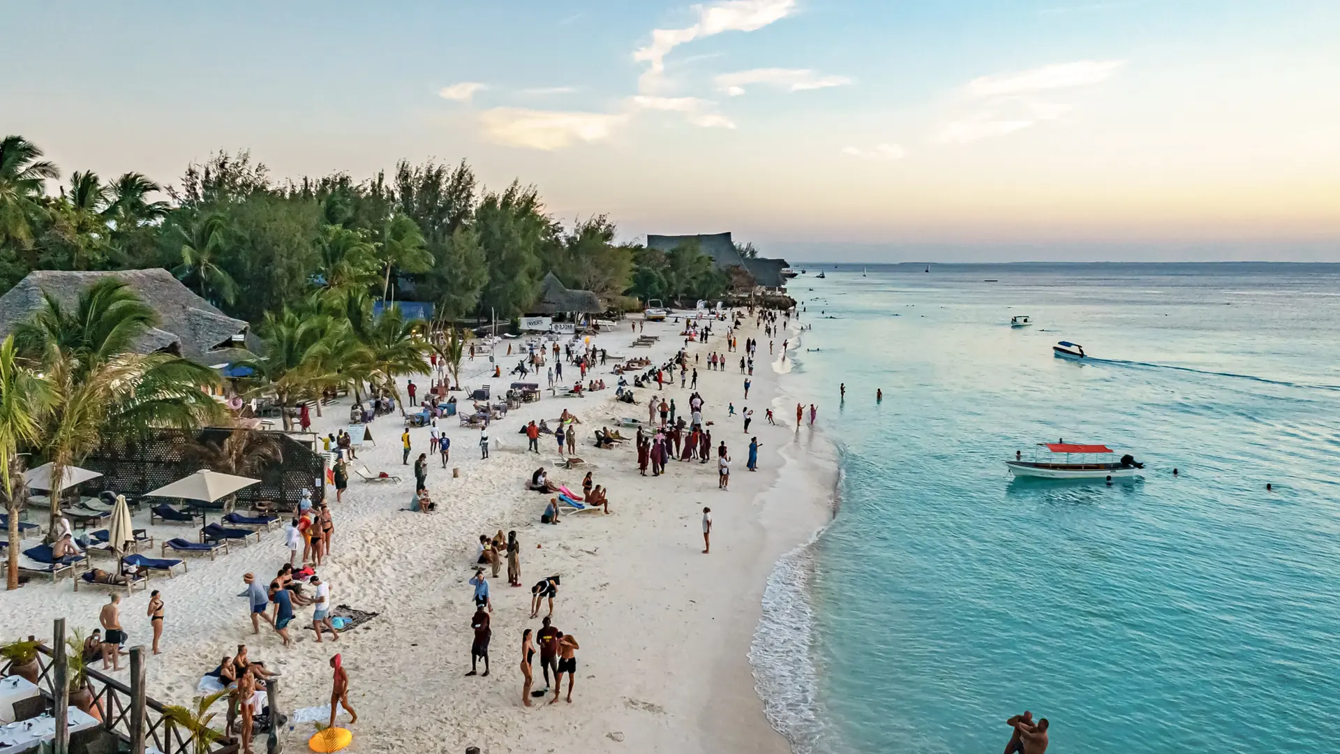 Sunny Nungwi shoreline with pale sand, turquoise sea and boats