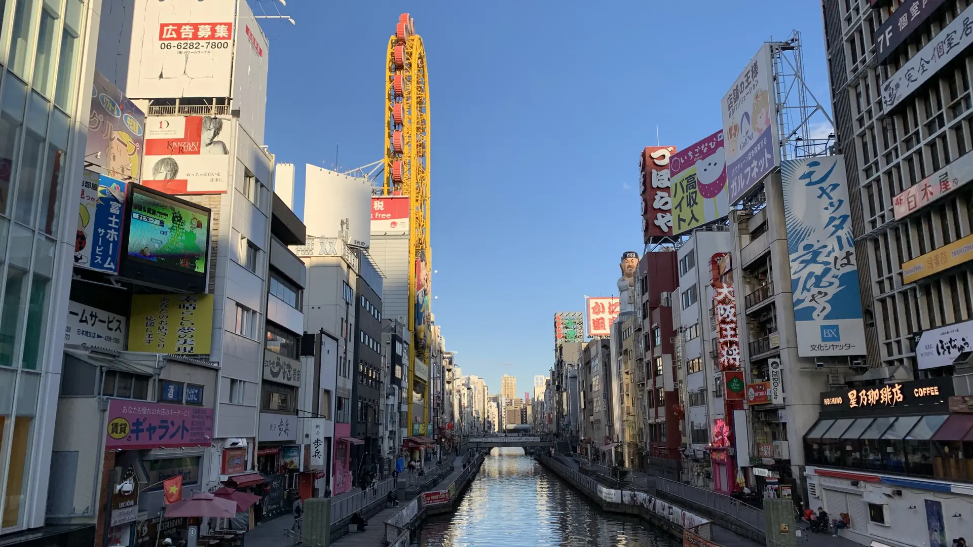Dotonbori canal, riverside walks and the yellow Don Quijote Ferris wheel beneath a clear blue Osaka sky