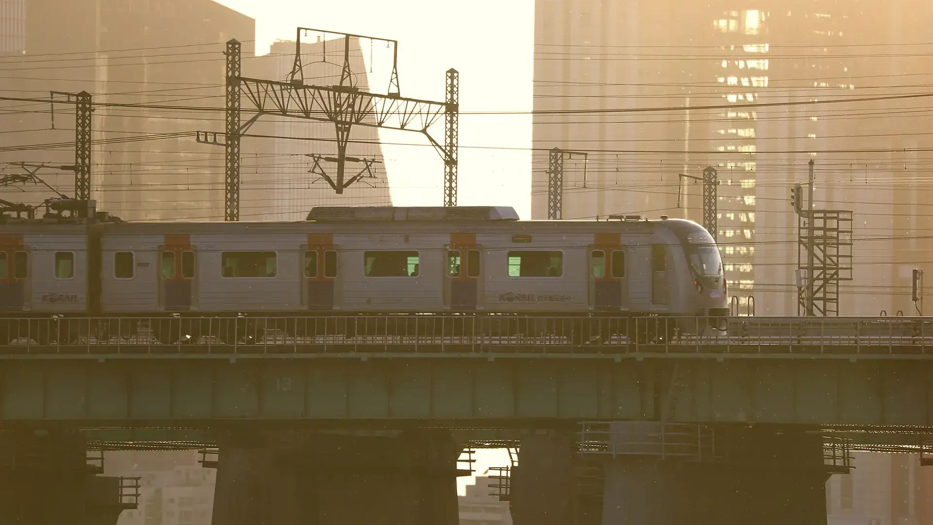 A Korail train crossing a bridge in Seoul at golden hour