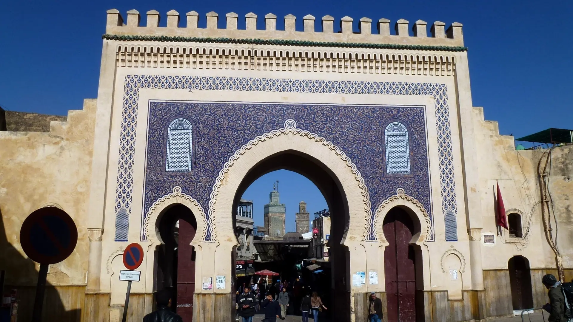 Blue tiled Bab Boujloud gateway opening into the Fez medina in daylight