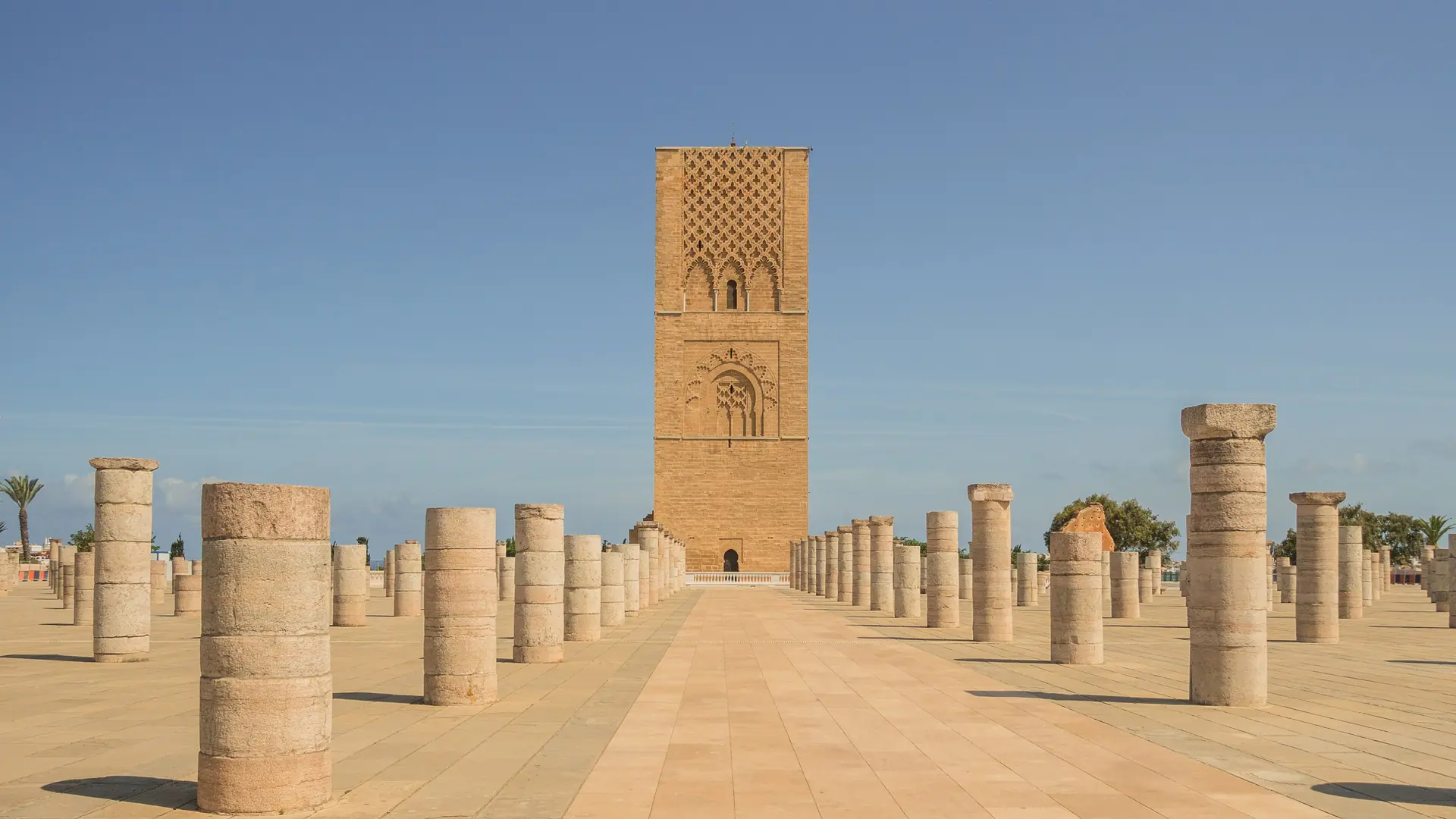 Hassan Tower above the sunlit mosque columns in Rabat