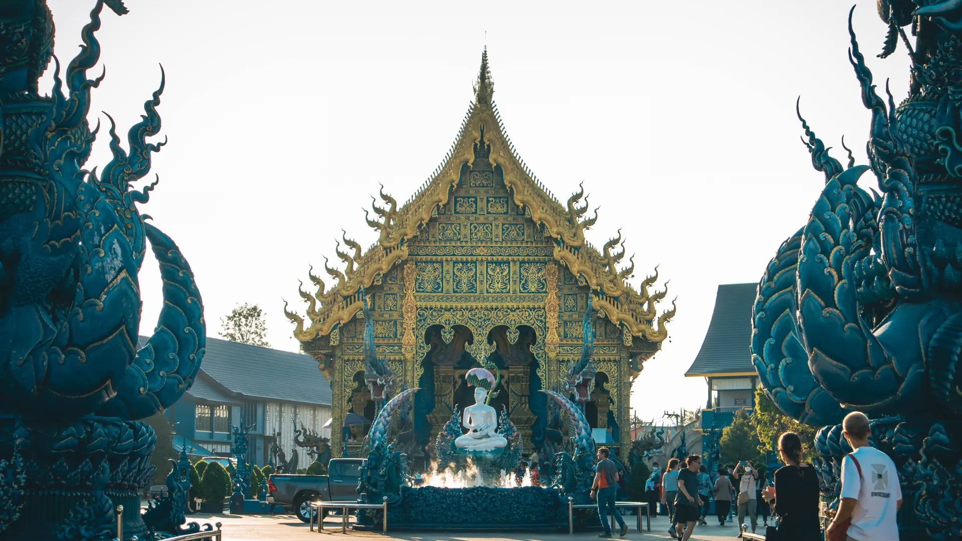 Blue sculpted guardians framing the entrance to Wat Rong Suea Ten