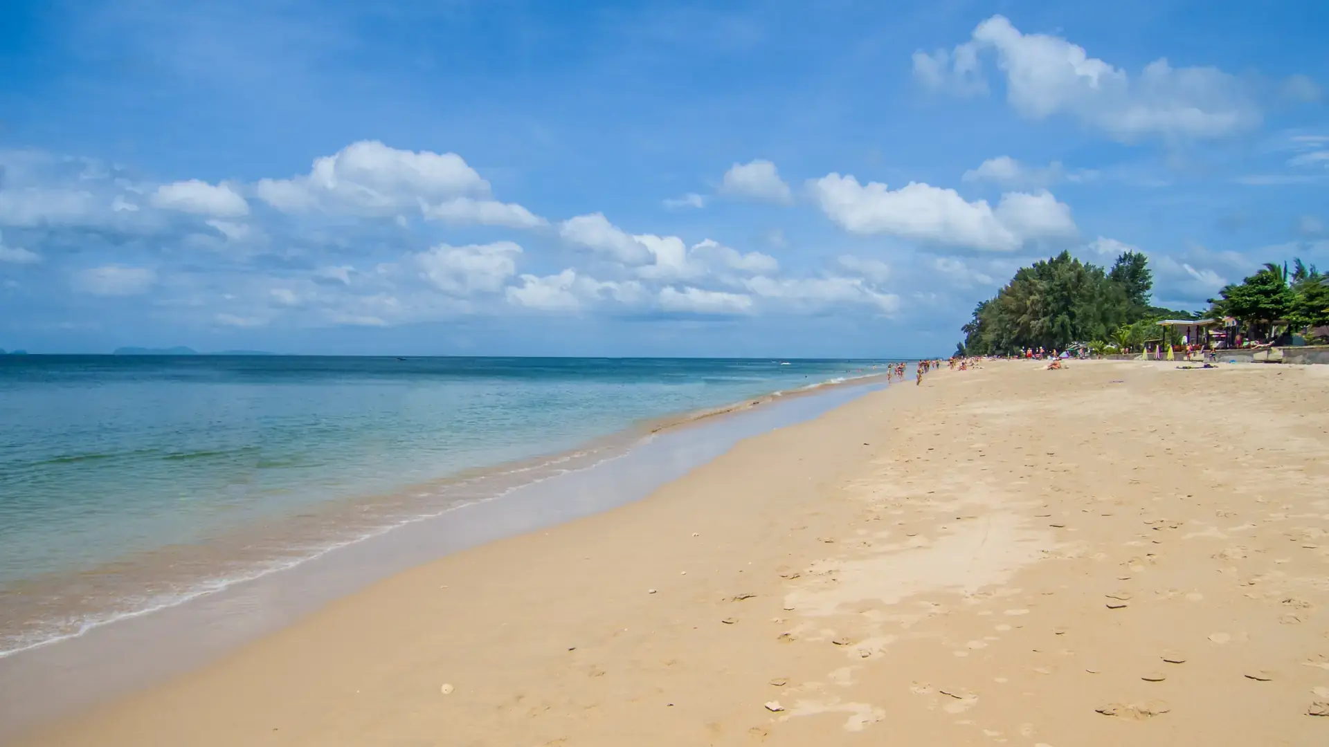 Sunny sandy shoreline on Koh Lanta, a wider island beach scene