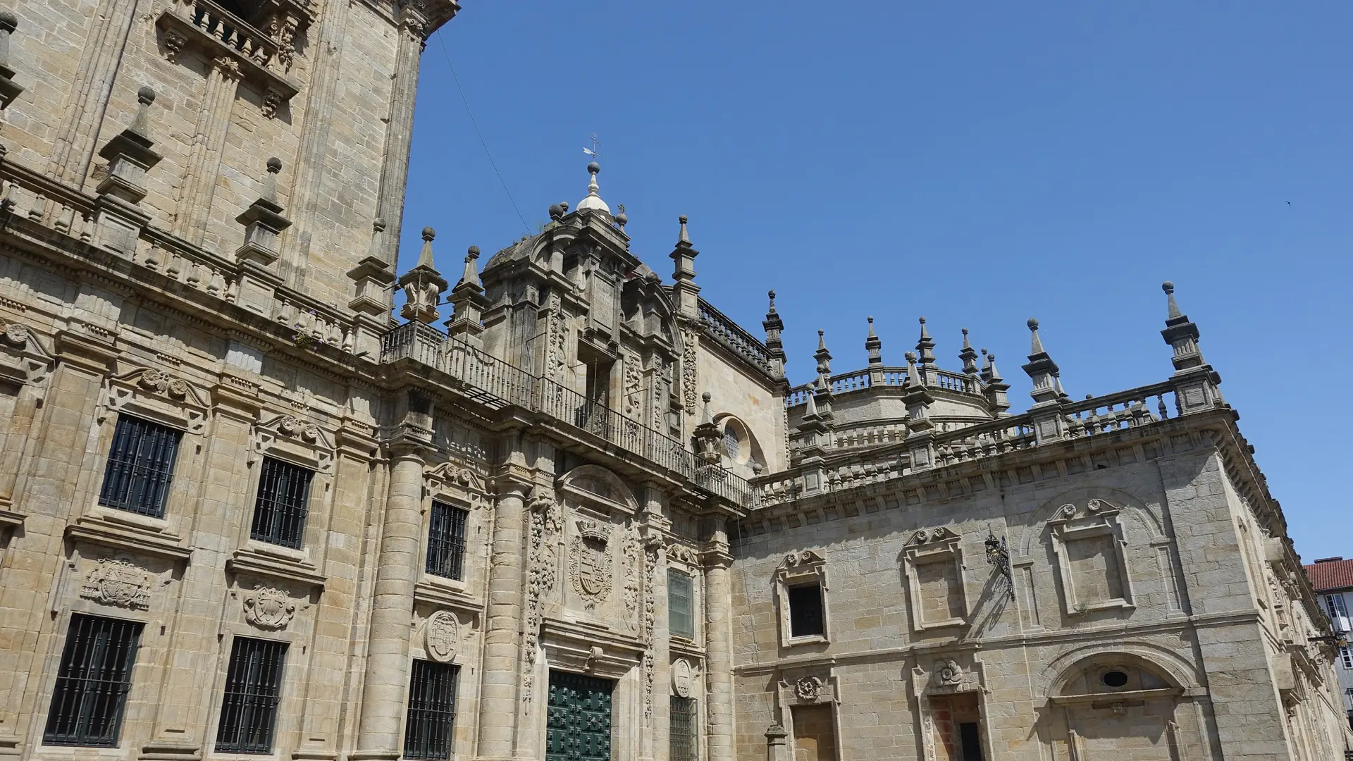 Sunlit granite façade of the Cathedral on Praza da Quintana
