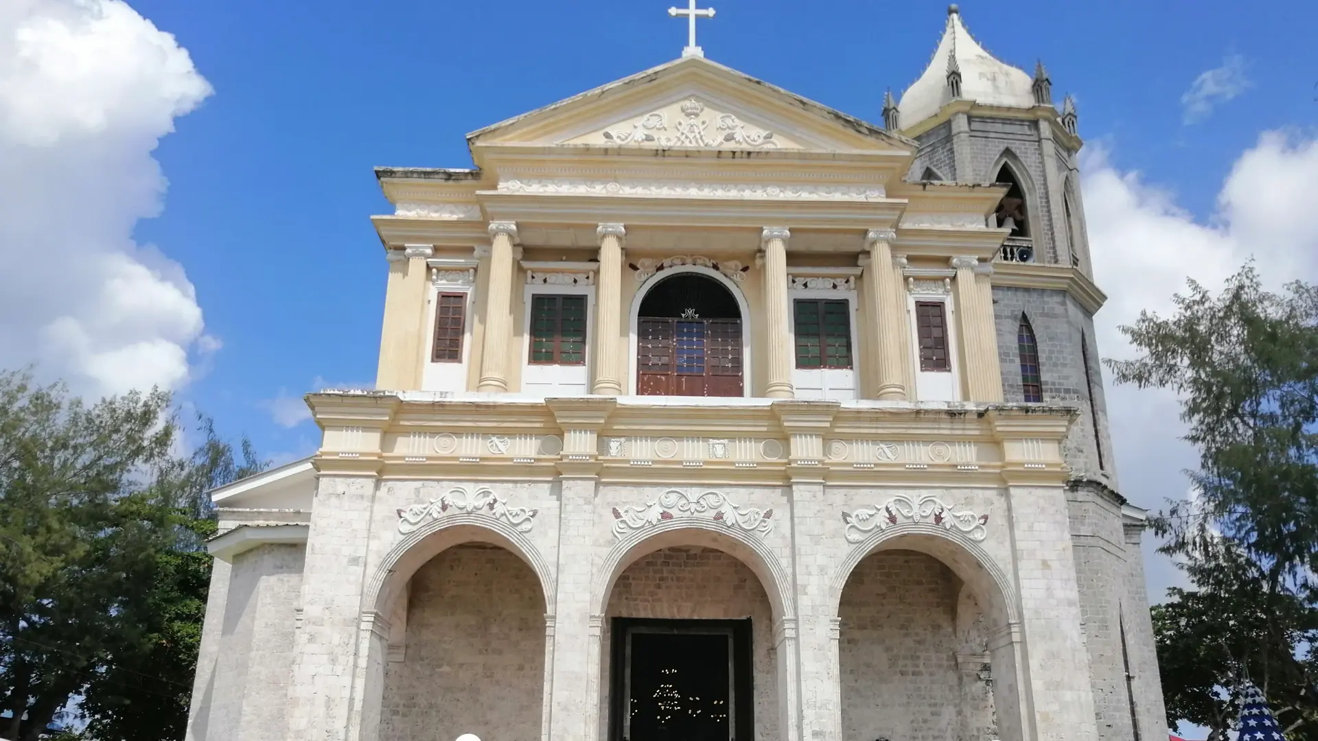The white coral-stone facade and bell tower of Dauis church on Panglao Island, Bohol