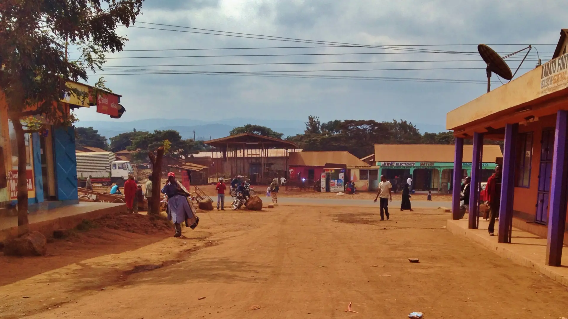 Sunlit roadside shops and red-earth street in Karatu, Tanzania