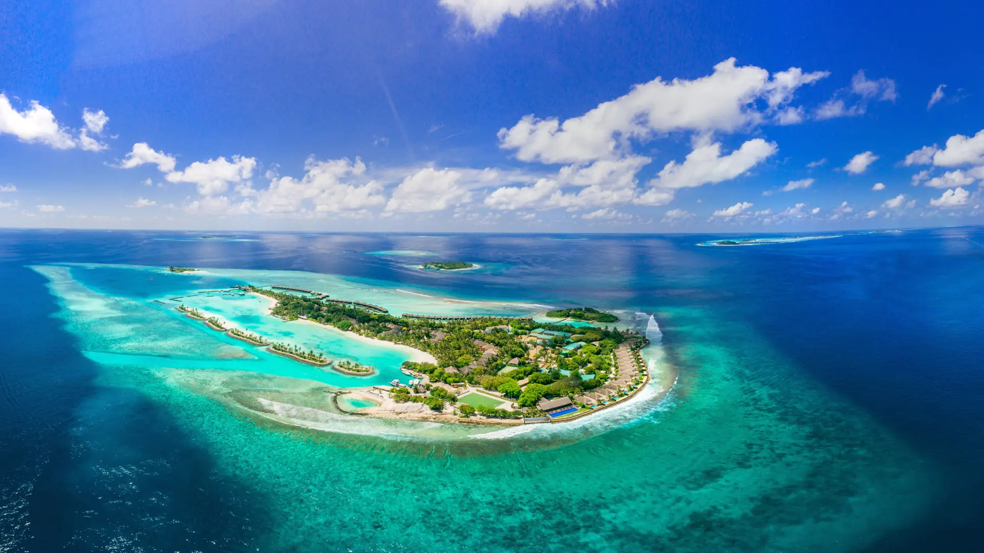 Aerial view of a turquoise lagoon and resort island in the Maldives
