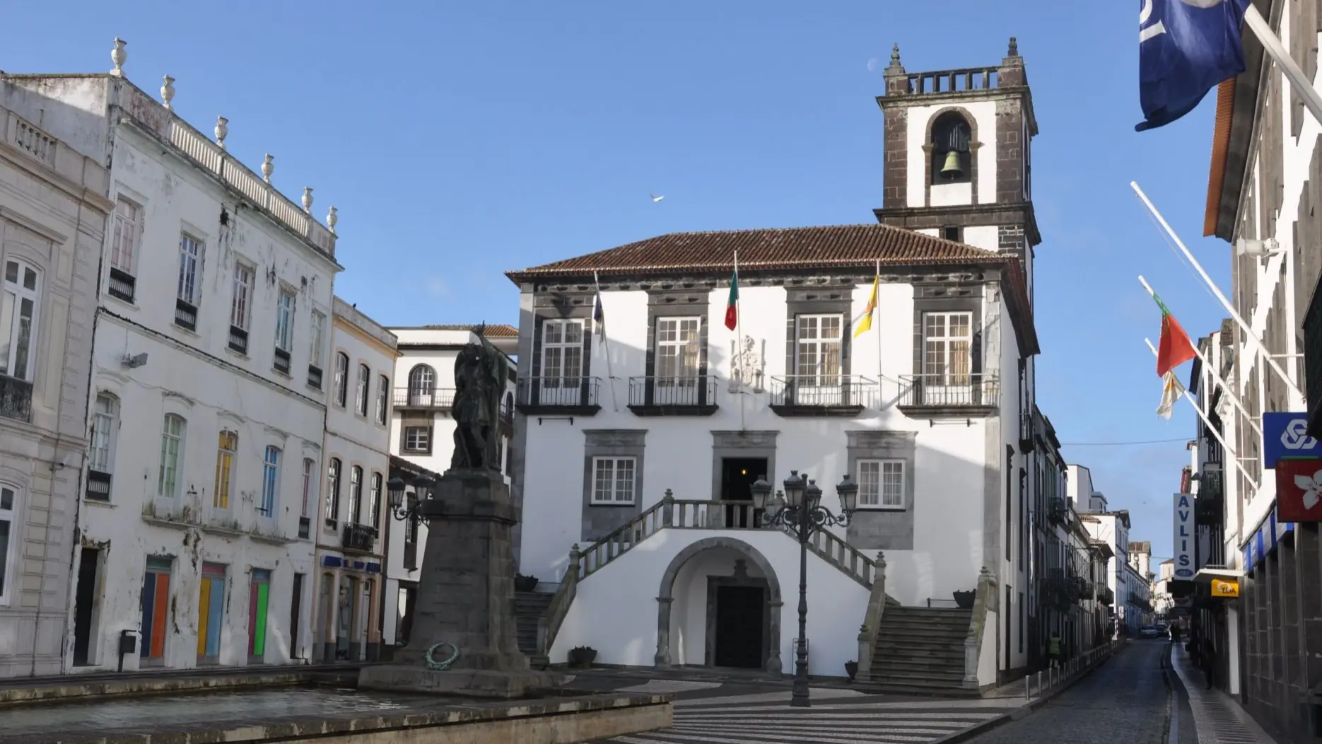 Ponta Delgada's City Hall square with a statue and black-and-white pavement under clear blue sky