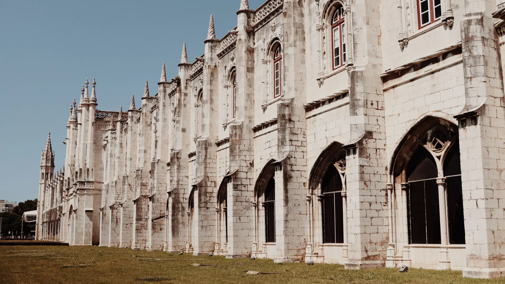 the ornate Manueline stonework and pinnacles of Jerónimos Monastery in Lisbon under a clear blue sky